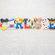 the word carlisle is made up of colorful letters and mickey mouse magnets on a white surface