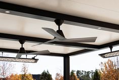 the ceiling fan is hanging from the ceiling in front of an open patio area with tables and chairs