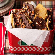 a red container filled with lots of different types of food on top of a table