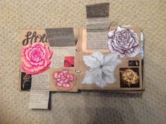 an open book with flowers on it sitting on top of a carpeted floor next to a wall