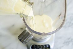 a blender filled with white liquid on top of a counter