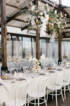 the tables are set with white linens and floral centerpieces for an elegant wedding reception