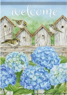 a welcome sign with blue hydrangeas and birds sitting on the fence next to it