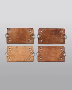 three brown leather tags with holes on them