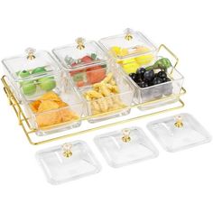 four trays with food in them on a white surface and gold trimming around the edges