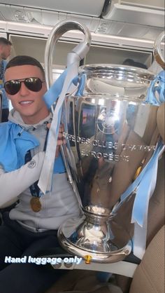 a man sitting in the back of an airplane holding up a trophy