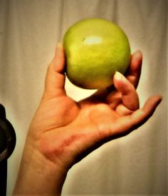 a person holding an apple in their hand