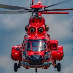 a red helicopter is flying through the air