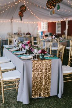 the tables are set up with gold sequin tablecloths and silver linens