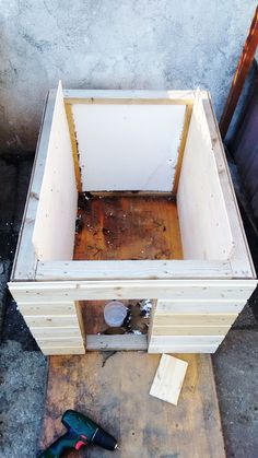 an unfinished wooden box sitting on top of a floor