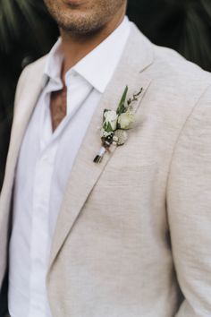 a close up of a person wearing a suit and flower in his lapel coat