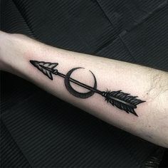 an arrow and ring tattoo on the arm