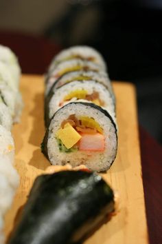 several sushi rolls are arranged on a cutting board