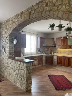 a kitchen with stone walls and wooden cabinets