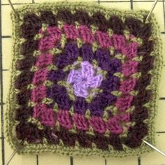 a crocheted square with a flower on it