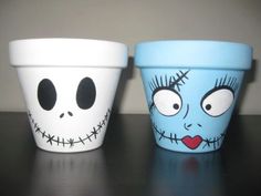 two cups with faces painted on them sitting next to each other