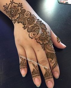 a woman's hand with henna tattoos on it