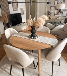 a dining room table with chairs and a rug on the floor in front of it