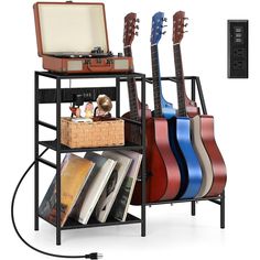 an electric guitar stand with three guitars on it and a record player next to it