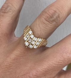 a woman's hand with a gold ring and diamond set band on her finger