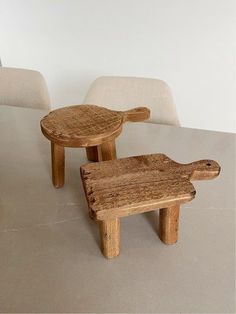 two wooden stools sitting on top of a table