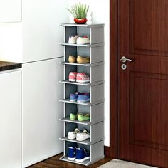 a shoe rack in the corner of a kitchen next to a door with shoes on it