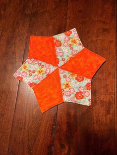 an orange piece of fabric sitting on top of a wooden floor