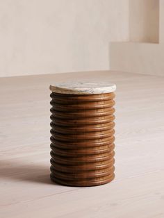 a stack of wooden discs sitting on top of a hard wood floor next to a white wall