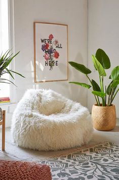 a living room with plants and rugs on the floor in front of a window