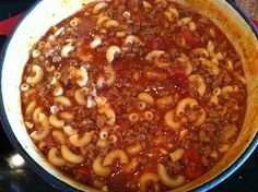 a large pot filled with pasta and sauce on top of a stove burner oven