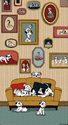 a couch with many dogs on it in front of a wall full of framed pictures