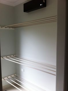 an empty walk in closet next to a wall mounted air conditioner