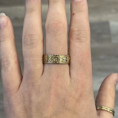 a woman's hand with two gold rings on her left and the middle finger