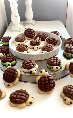 there are many decorated cookies in the shape of turtle's on a cake platter