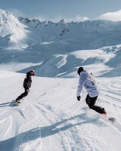 two snowboarders going down a snowy mountain slope