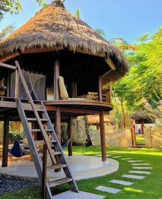 a round house with a thatched roof and stairs leading to the upper level deck