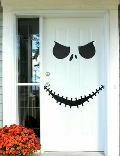 a front door decorated for halloween with a jack - o'- lantern face