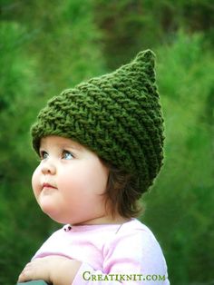 a small child wearing a green knitted hat