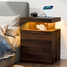 a bed with a night stand next to it on top of a wooden flooring