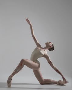 a woman in white leotard and ballet shoes