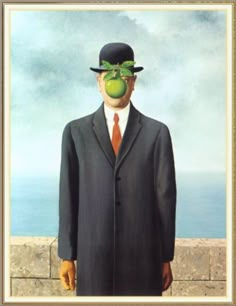 a man in a suit and hat with an apple on his face