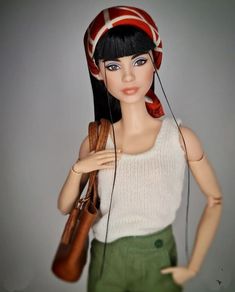 a doll wearing a hat and holding a purse