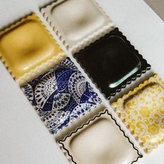 four different types of decorative plates on a white counter top with yellow and blue designs