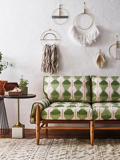 a green and white couch sitting on top of a wooden floor next to a table