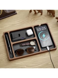 an assortment of personal items in a wooden box on a table with other things to include