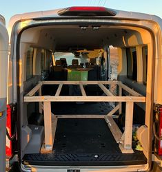 the back end of a van with an open trunk and two wooden racks in it