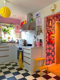 a kitchen with checkered flooring and pink walls