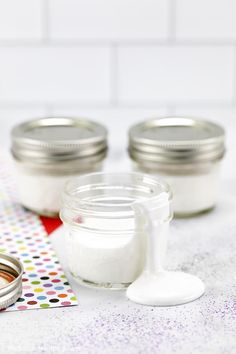 there are three jars and two spoons on the table