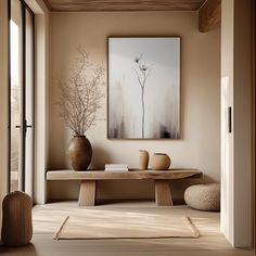 a room with a table and vases on the floor next to a large painting