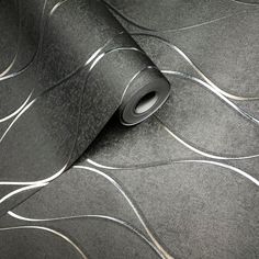 a black wallpaper with silver lines on it and a roll of tape next to it